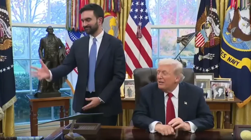 New York City Mayor-elect Zohran Mamdani standing in a professional political setting with a neutral background — global news editorial portrait.